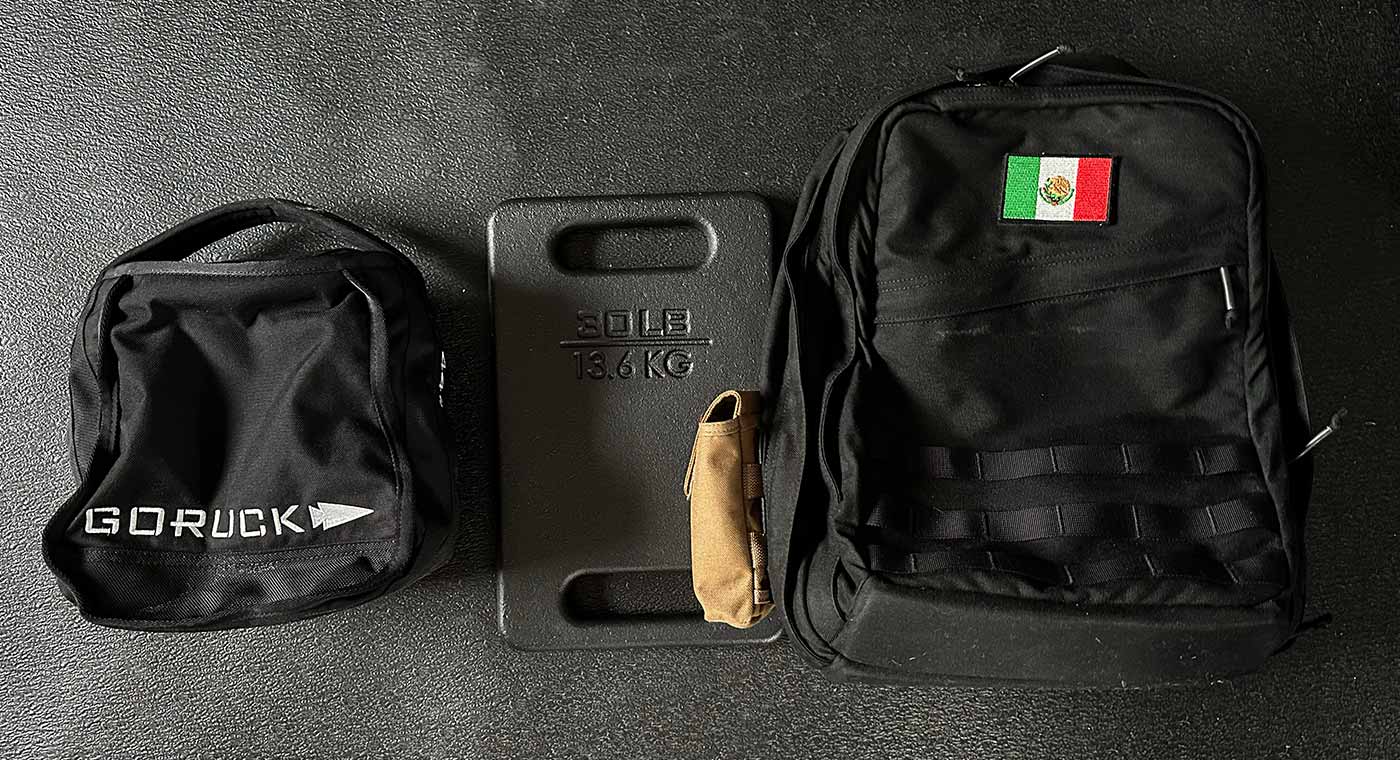 Photo of my GoRuck rucksack, weight plate, and sandbag.